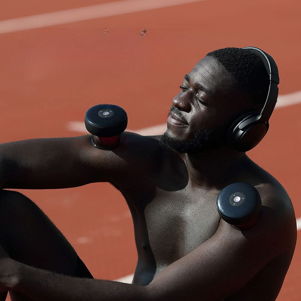 Mand sidder med Smart Cupping enhed på hver skulder
